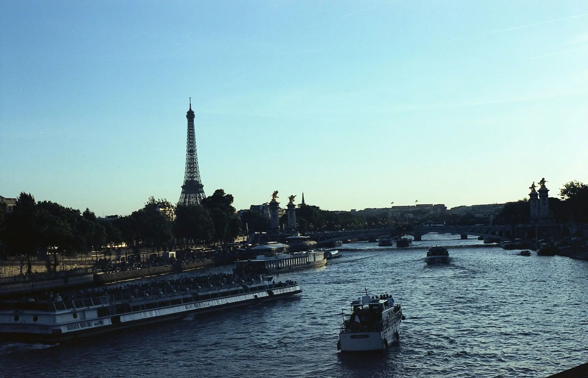 The Eiffel Tower and boats on the Seine seen from across the river The Eiffel Tower and boats on the Seine seen from across the river
